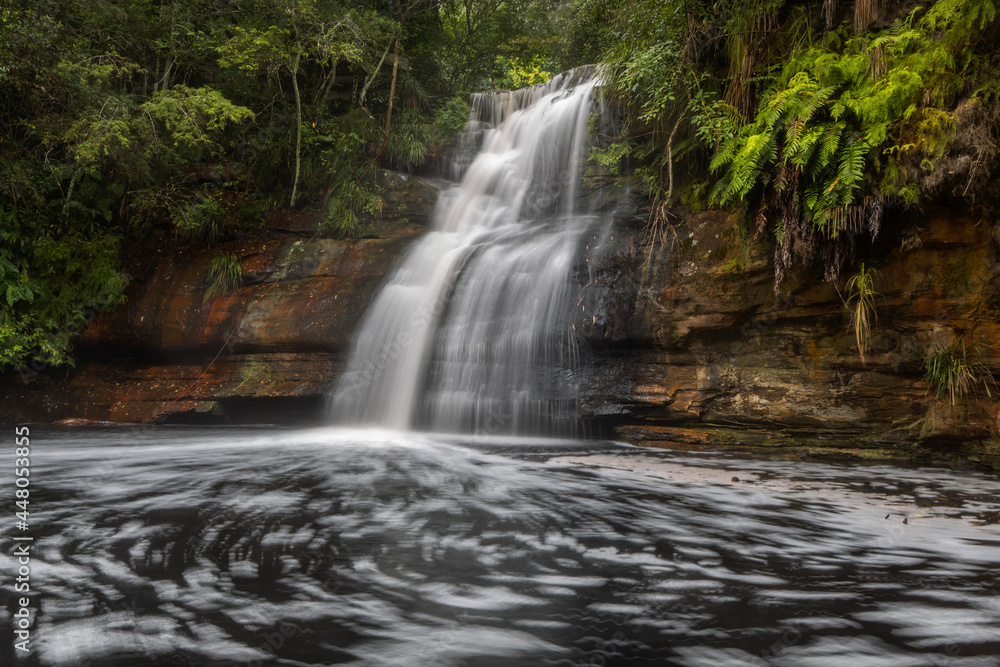 a waterfall with trees on the side of a river a waterfall with trees on the side of a river