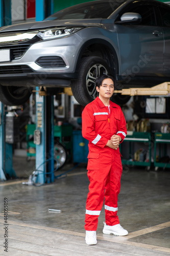 Portrait of a Asian mechanic working in his car service garage. Car maintenance and auto service garage concept.