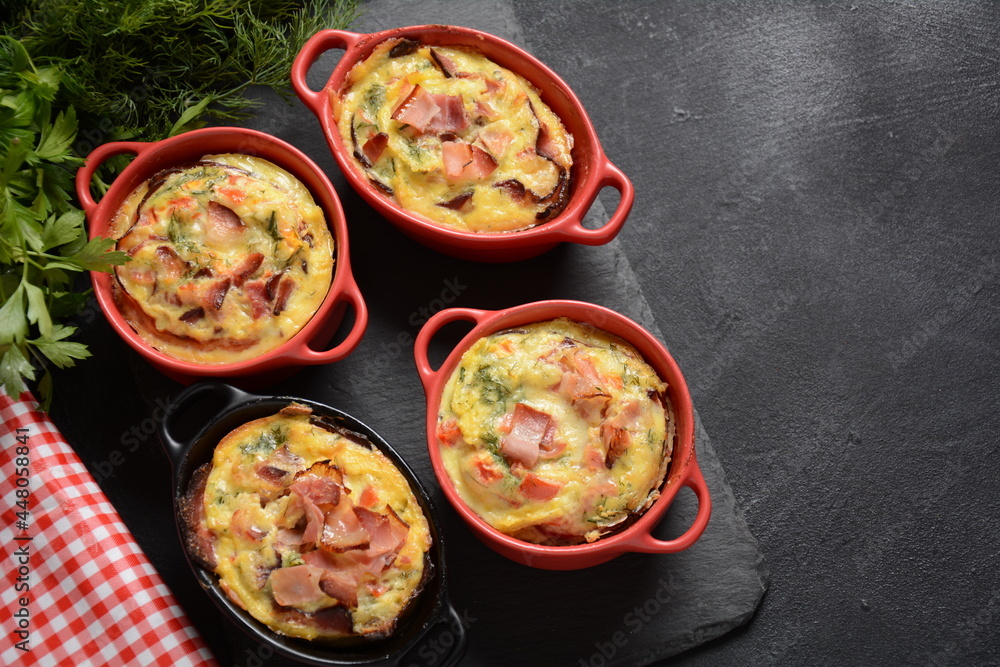 Omelette  with bacon, grated parmesan and greens in ceramic cocotte. Tasty breakfast