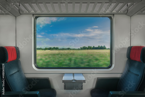 Blick aus dem Fenster eines fahrenden Zuges auf eine Landschaft