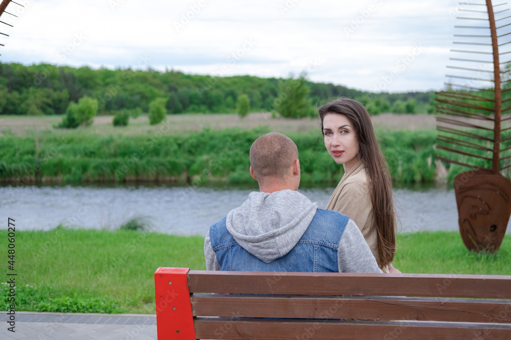 beautiful young couple sitting on a bench in the park