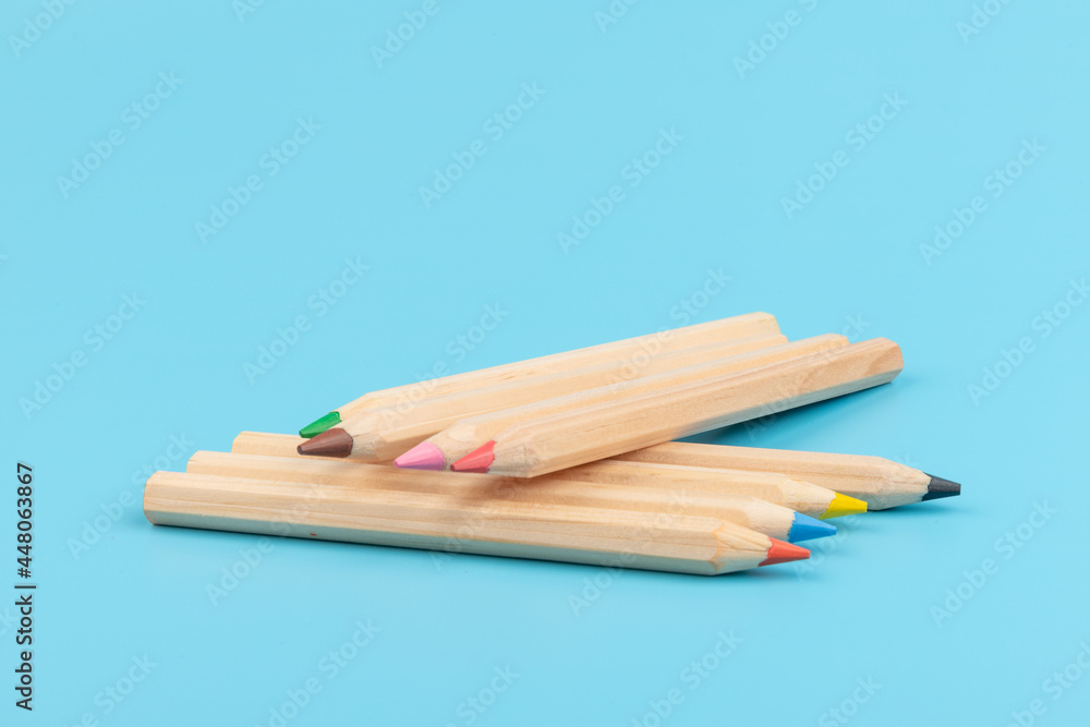 Obraz premium Wooden colorful ordinary pencils isolated on blue background. Back to school