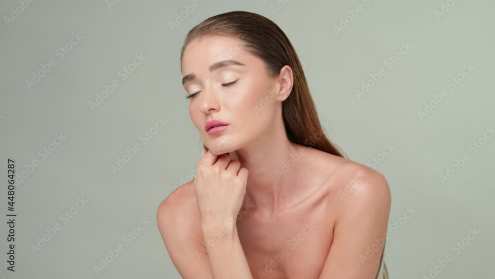 Beautiful Young Woman with Clean Fresh Skin standing over light grey background Beautiful Young Woman with Clean Fresh Skin standing over light grey background