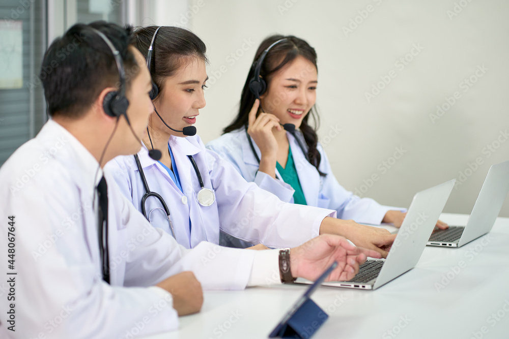 Team of asian doctors waer headset help people or patients with answers question of healthcare or medical via online service Team of asian doctors waer headset help people or patients with answers question of healthcare or medical via online service