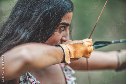 Photo detail of a woman training shooting with a bow.