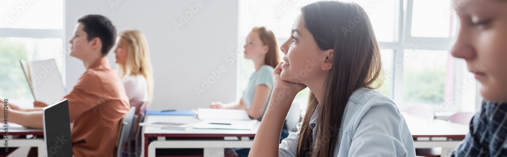 side view of teenage pupils sitting at desk in classroom, banner side view of teenage pupils sitting at desk in classroom, banner