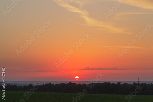 Colorful bright sunset in the field with clouds.