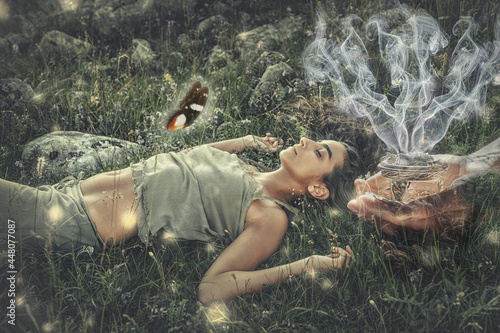 woman on meadow, incense in a woman hand.