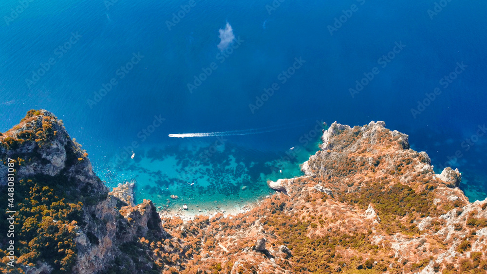 Speedboat speeding up along Capri coastline on a beautiful summer morning, Italy
