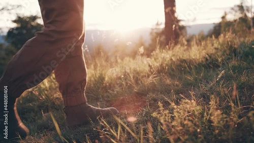 POV point of view shot of man or woman walking on wet grass, morning with sunshine. Midium shot Slow motion. photo