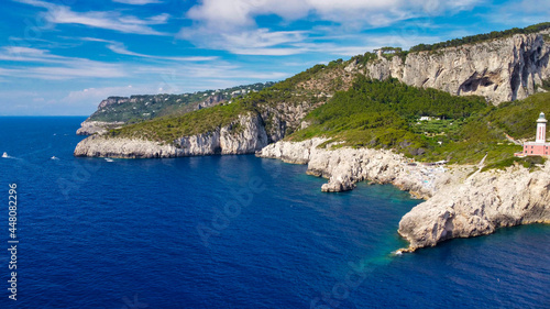 Lighthouse and Beach of Capri in summer season. View from a moving drone.