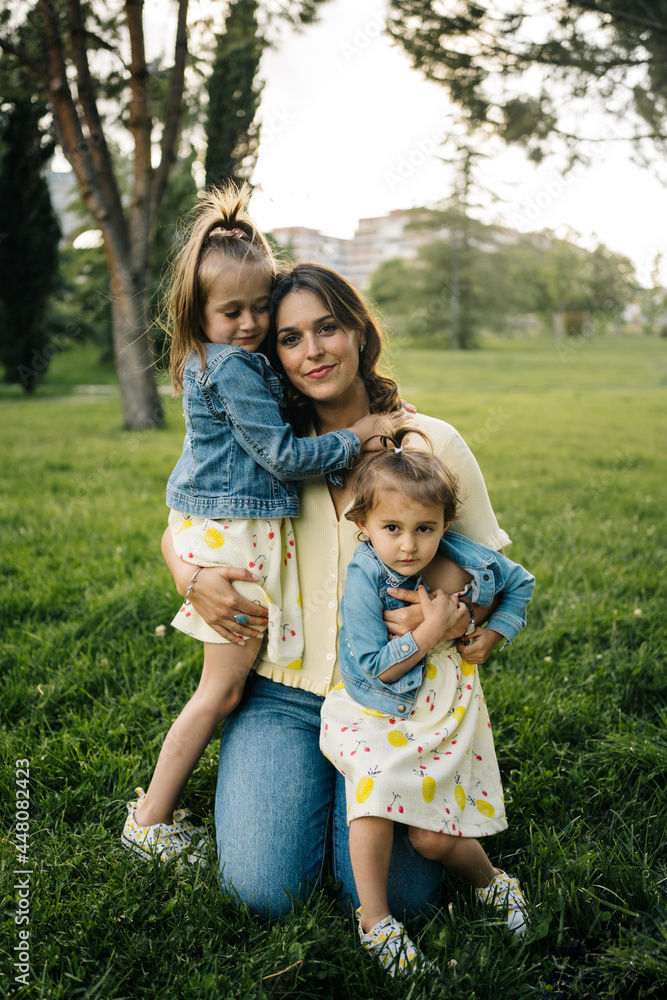 Mother with little daughters resting in park Mother with little daughters resting in park