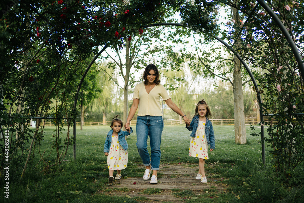 Mother with little siblings walking in park Mother with little siblings walking in park