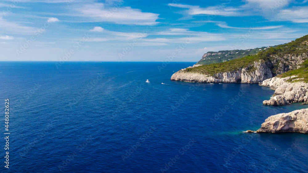 Lighthouse and Beach of Capri in summer season. View from a moving drone.