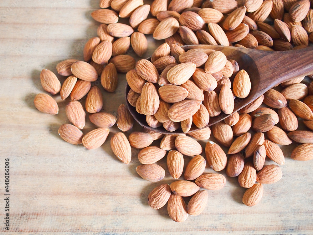 Seed almonds on wooden spoon on wood background. Seed almonds on wooden spoon on wood background.