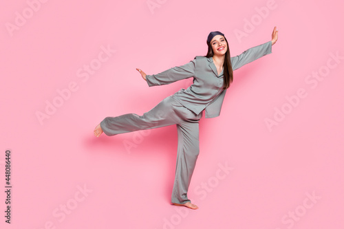 Photo of childish charming young woman nightwear smiling dancing isolated pastel pink color background