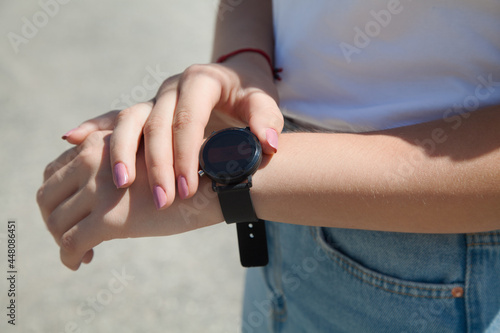 Hand watch on the fashionable woman's hand. Black color.