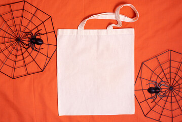 White tote bag canvas fabric. Cloth shopping sack mockup with copy space with spiderweb on orange background.