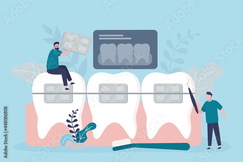 Team of dentists provides patient with orthodontic treatment. Orthodontist installs dental braces