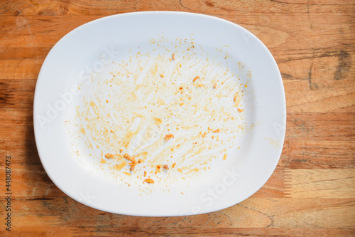 A white plate of food on the table after eating