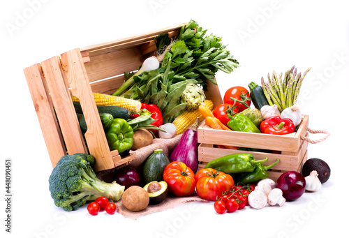 Wooden boxes full of fresh vegetables on a white background, ideal for a balanced diet