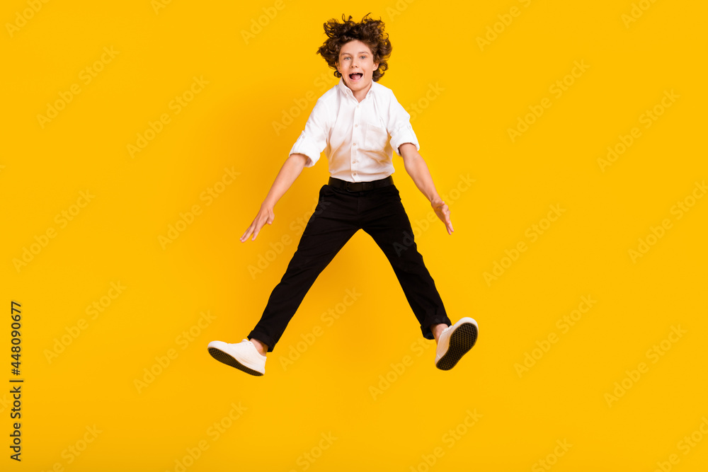 Full length photo of funny small brunet boy jump wear uniform isolated on yellow color background