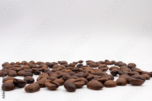 Coffee grains scattered on a white background