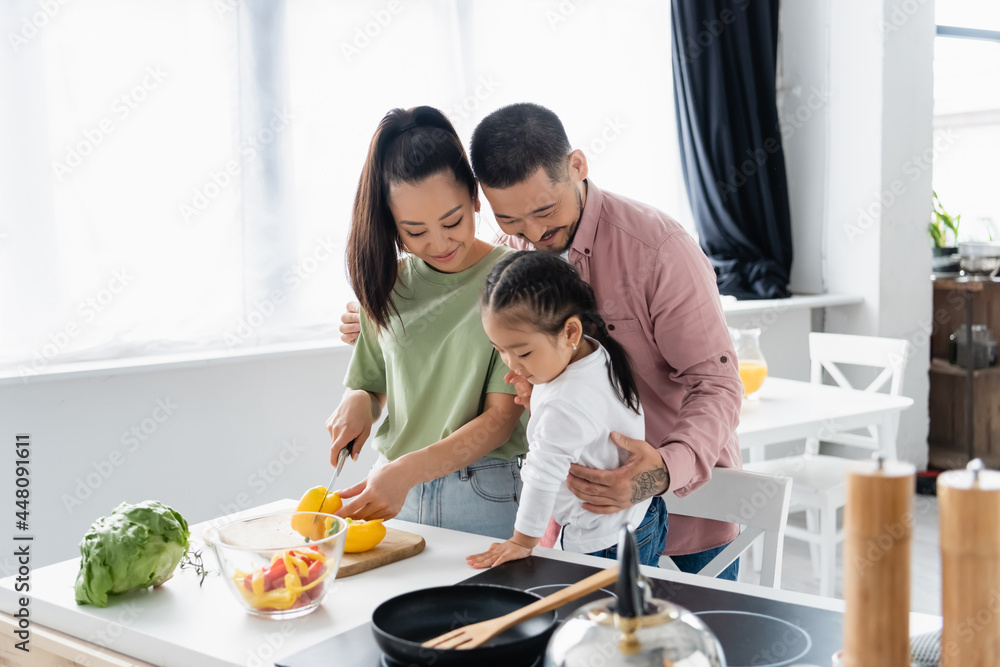 happy asian family preparing salad in kitchen happy asian family preparing salad in kitchen