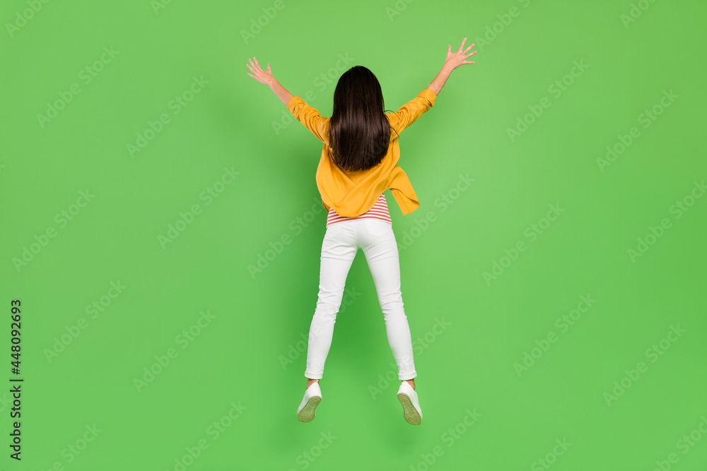 Full body back photo of funky brown hairdo young lady jump wear shirt trousers sneakers isolated on green color background Full body back photo of funky brown hairdo young lady jump wear shirt trousers sneakers isolated on green color background