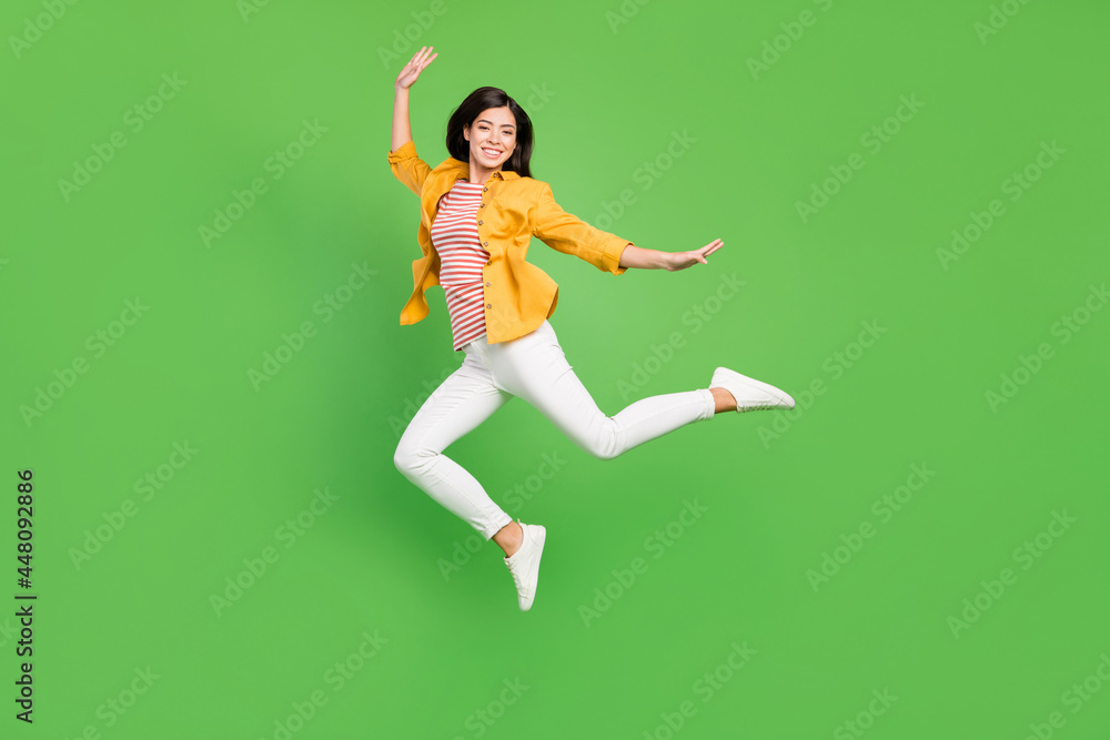 Full body profile photo of nice brown hairdo millennial lady jump wear shirt trousers sneakers isolated on green color background