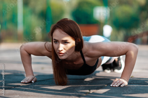 Purposeful woman does push-ups. Sports training, active lifestyle for the thirties.