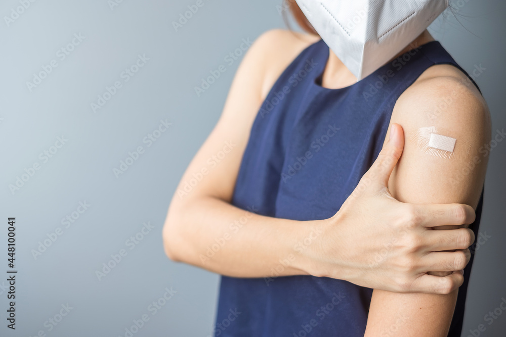 woman showing her arm with bandage after receiving covid 19 vaccine. Vaccination, herd immunity, side effect, vaccine efficiency and Coronavirus pandemic
