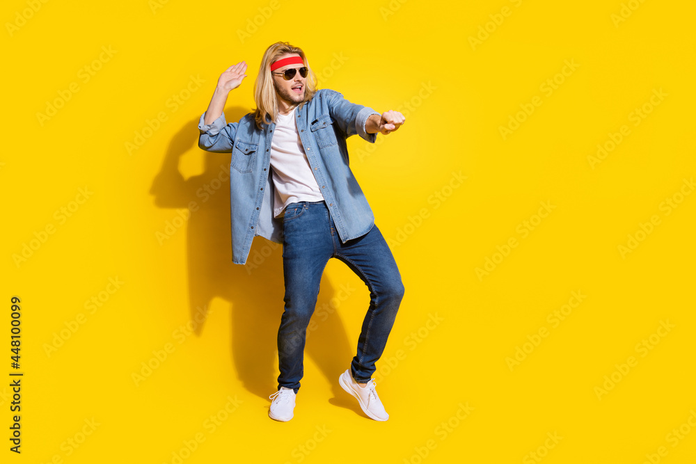 Photo of strong charming young guy dressed denim shirt smiling dancing empty space isolated yellow color background Photo of strong charming young guy dressed denim shirt smiling dancing empty space isolated yellow color background