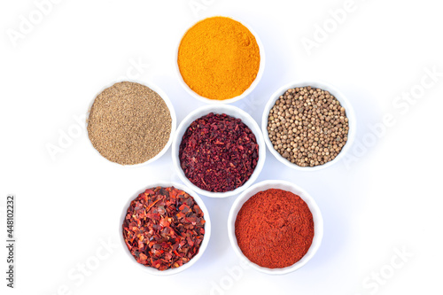 Bowls of different seasoning organic spices isolated on white