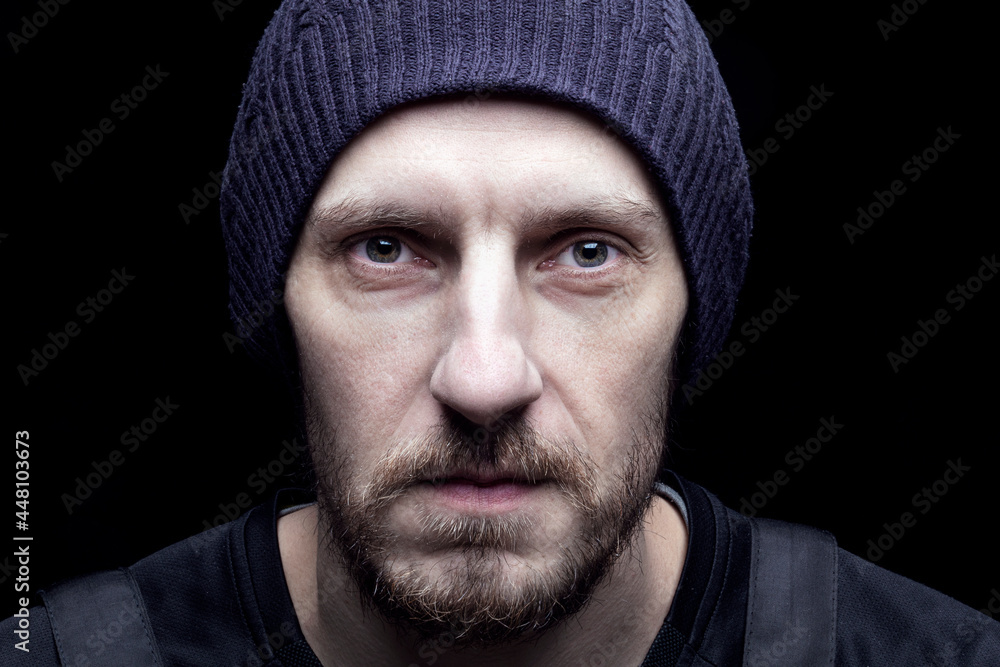 portrait of a 30-year-old man, a thoughtful look close-up. The image of a hipster with a beard and a black cap. A smart tense expression on his face, as if he is thinking about serious problems portrait of a 30-year-old man, a thoughtful look close-up. The image of a hipster with a beard and a black cap. A smart tense expression on his face, as if he is thinking about serious problems