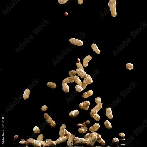 Realistic freeze motion of flying peanuts on black background