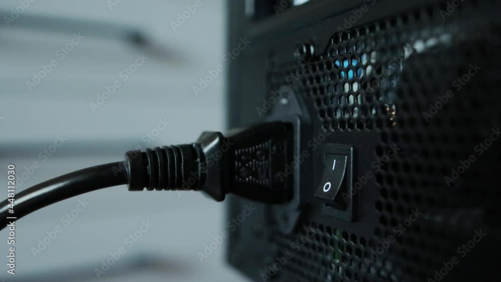 Defective power cord in the computer that powers the power supply. Man's hand straightens an electrical wire, close-up Defective power cord in the computer that powers the power supply. Man's hand straightens an electrical wire, close-up