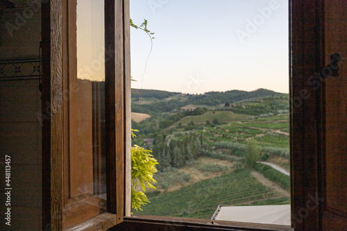 Ausblick aus einem Holzfenster in der Toscana in die Weinberge