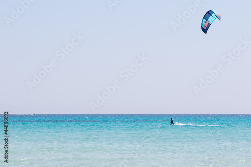 July 23, 2021: boy practicing kitesurfing in the crystal sea near the beach of La Cinta, Sardinia