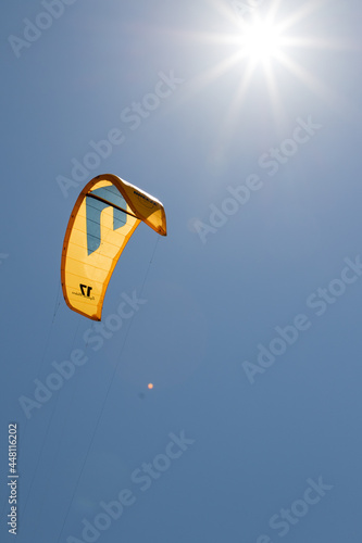 July 23, 2021: Sunbeams illuminate the kitesurf sail near the beach of La Cinta, Sardinia.