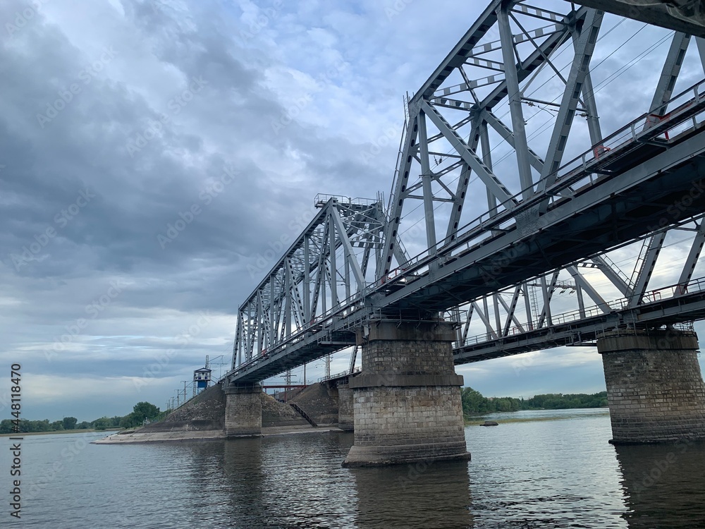 The gray Samara railway bridge over the surface of the Samara river; photo from the river The gray Samara railway bridge over the surface of the Samara river; photo from the river