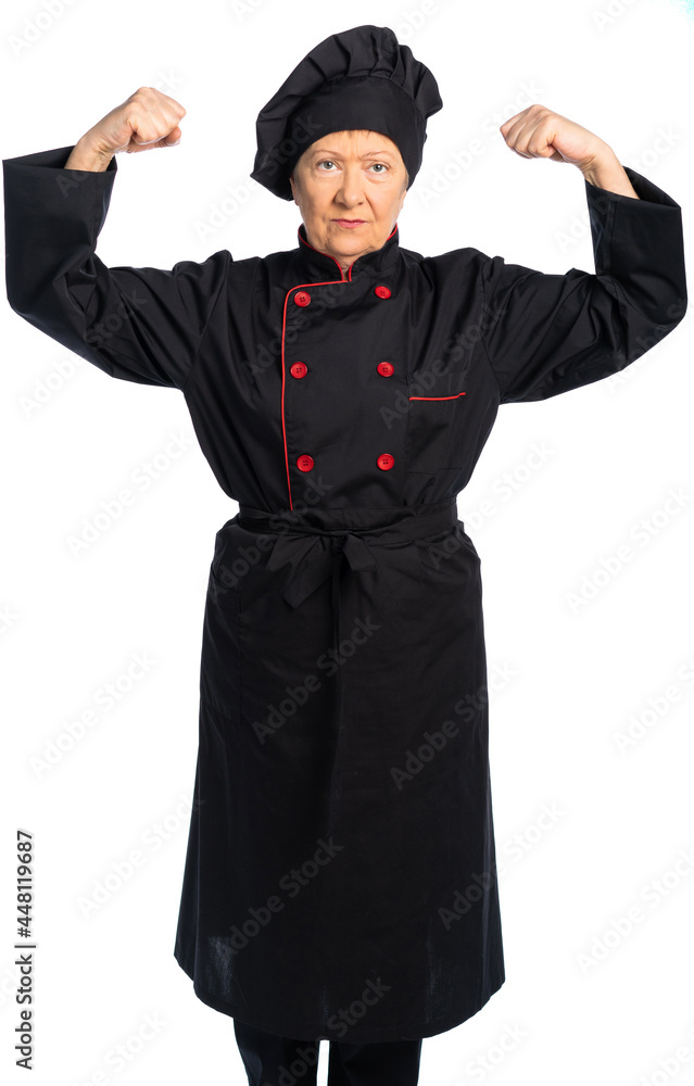 woman chef in black uniform. apron, shirt, hat. elderly woman. the lady stands straight and looks at us, shows strength, biceps. white background, isolated woman chef in black uniform. apron, shirt, hat. elderly woman. the lady stands straight and looks at us, shows strength, biceps. white background, isolated