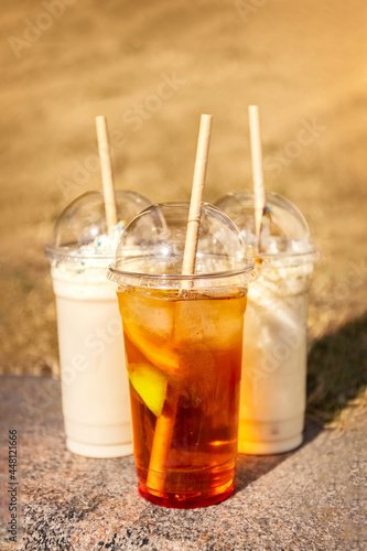 Summer drinks in plastic glasses with a lid and straws. Take away. Concept. Poster. Photo