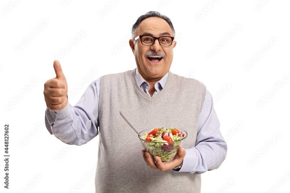 Cheerful mature man holding a healthy fresh salad in a bowl and showing thumbs up