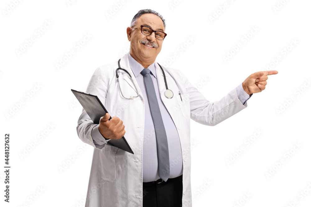 Smiling mature doctor standing with a clipboard and pointing Smiling mature doctor standing with a clipboard and pointing