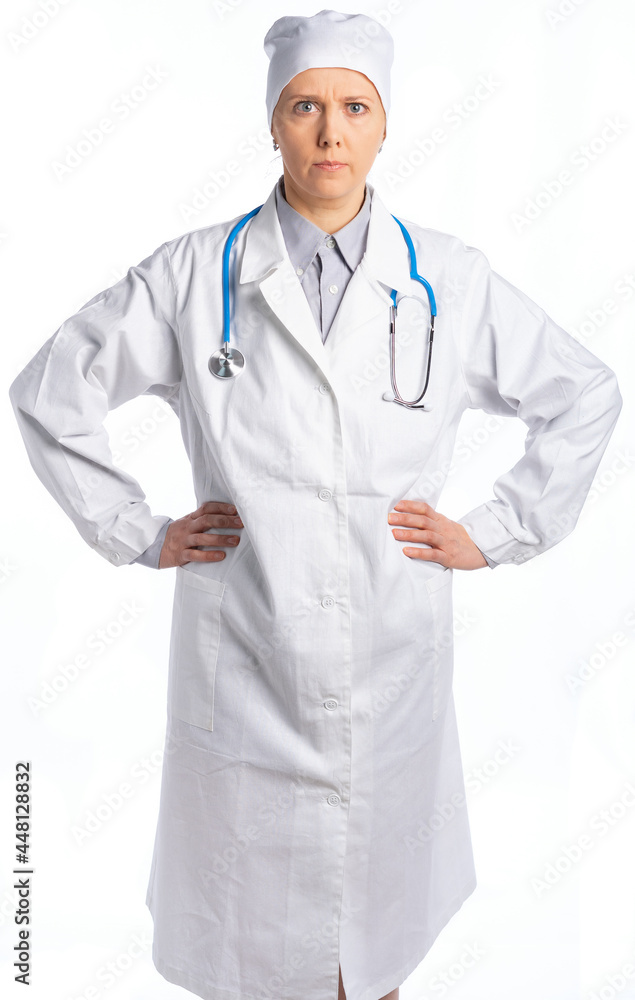 female doctor in a white coat and hat. the stethoscope hangs around the doctor's neck, she put her hands on her hips. the therapist is angry, frowned. isolated white background female doctor in a white coat and hat. the stethoscope hangs around the doctor's neck, she put her hands on her hips. the therapist is angry, frowned. isolated white background