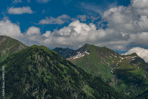 Summer valley with Grossarler Ache small river and blue cloudy sky