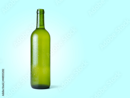 Bottle of fresh white wine isolated from the blue background with copy space