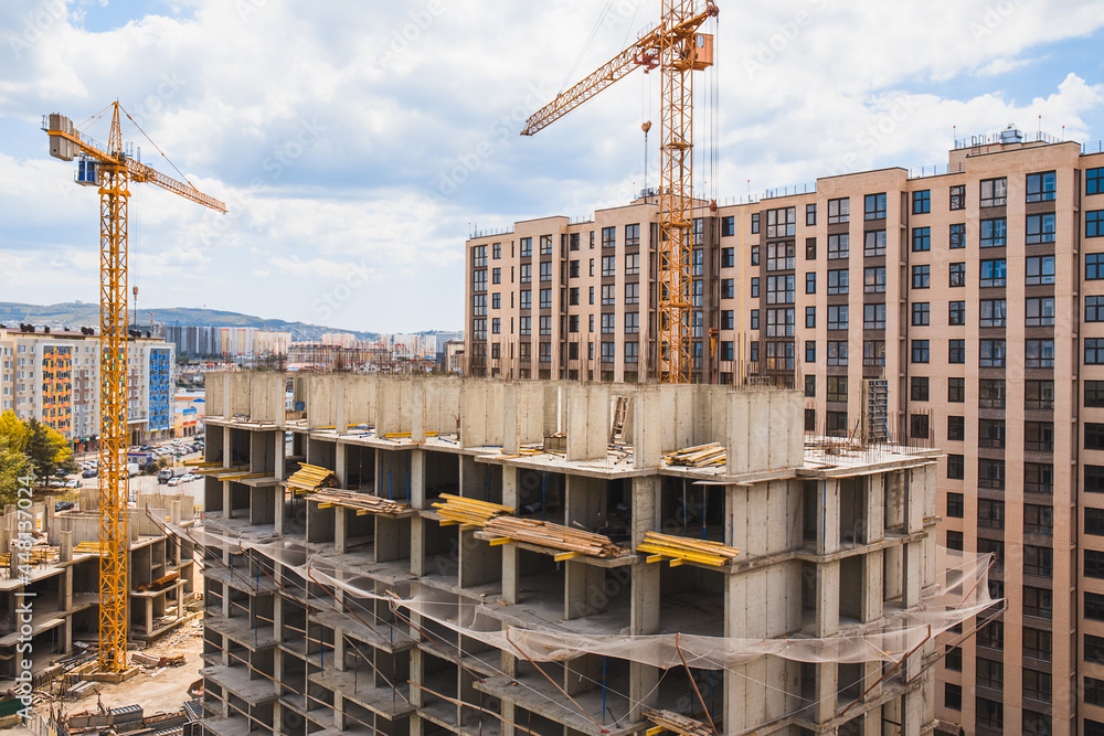 Modern construction site with cranes. Incomplete building construction Modern construction site with cranes. Incomplete building construction