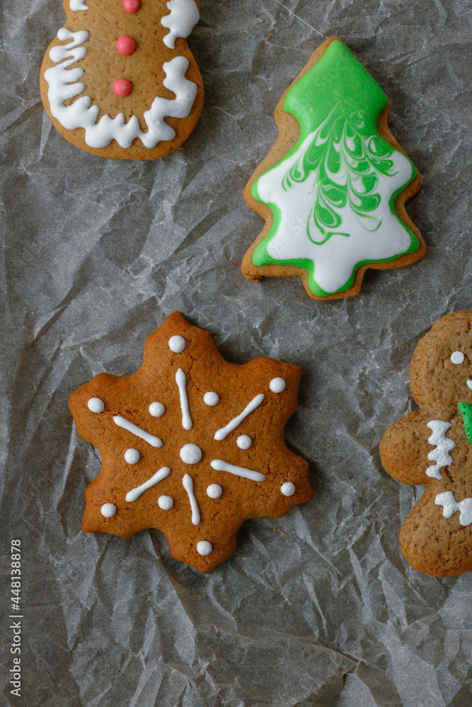 christmas gingerbread cookies with frosting on baking parchment. Snowflake, gingerbread man, christmas tree. 
